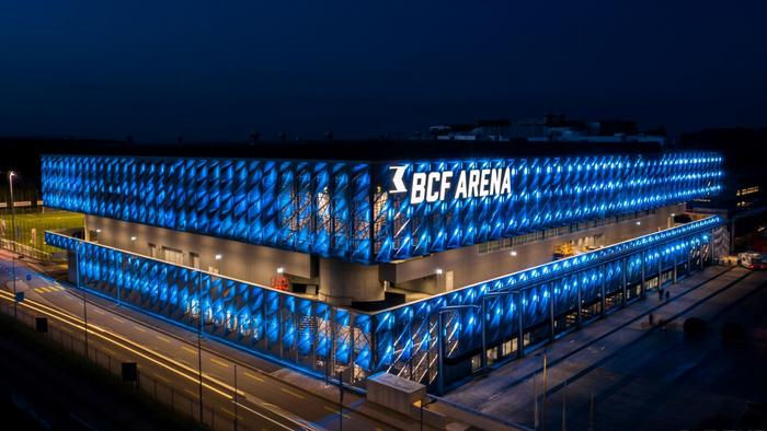 BCF Arena Fribourg bei Nacht mit blau beleuchteter Fassade